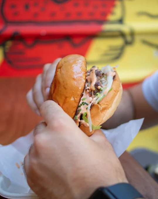 Smash burger στο χέρι μπροστά στο γκράφιτι